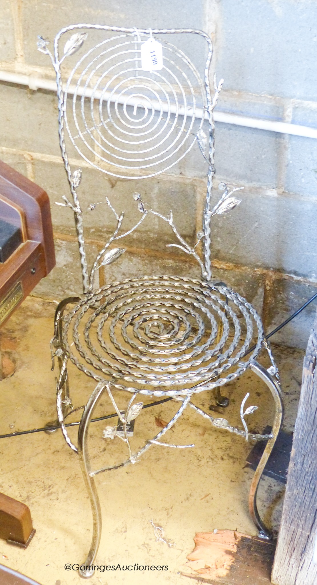 A single metalwork chair, foliage and floral decoration, 92cm high, 37cm wide.